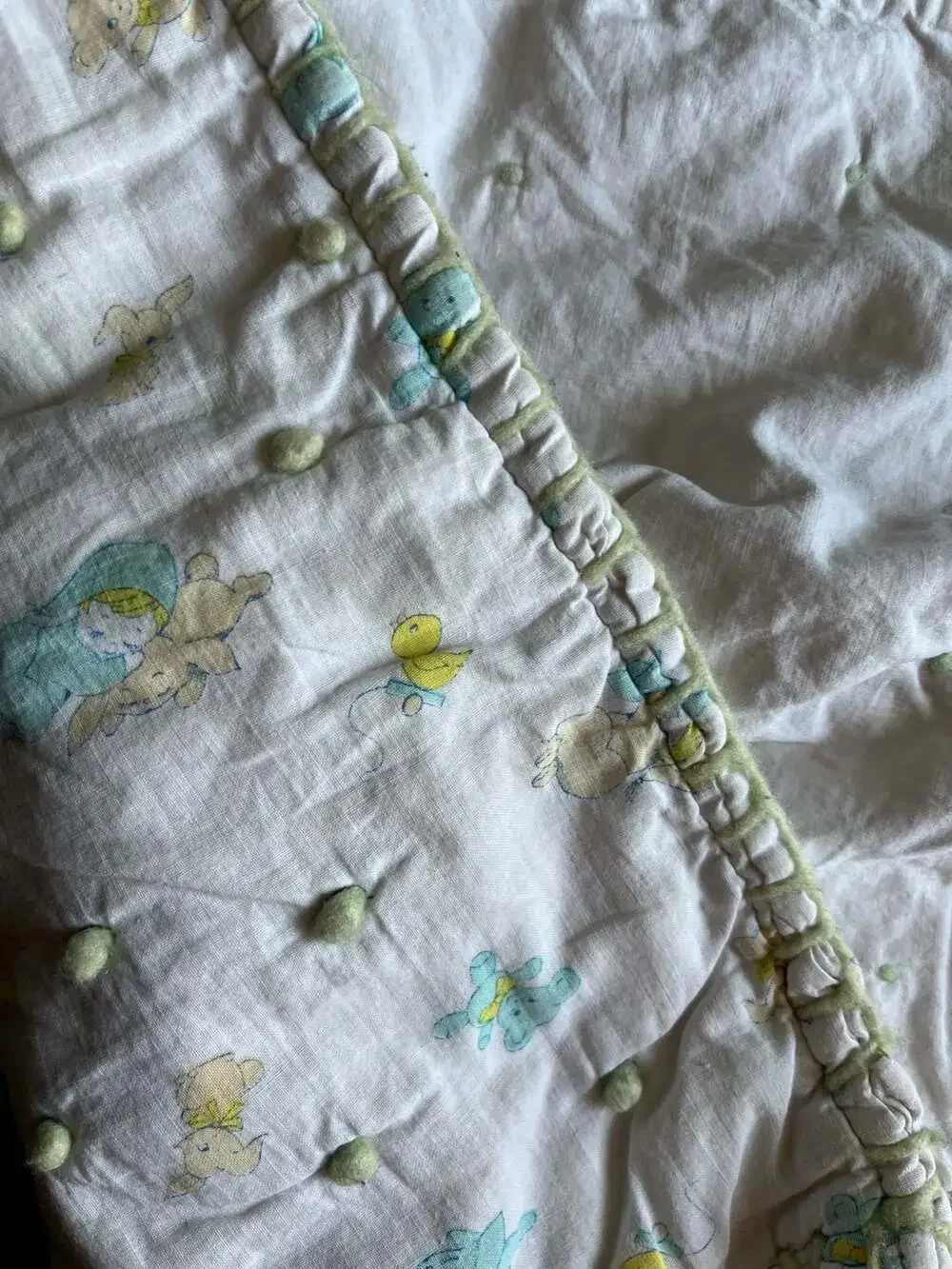 Vintage Style Baby Nursery Crib Quilt with Pom-Pom Accents and Animal Print